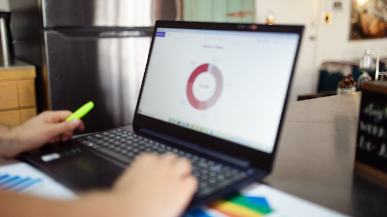 Freelancer using a laptop at a desk to review invoice records and overdue payments