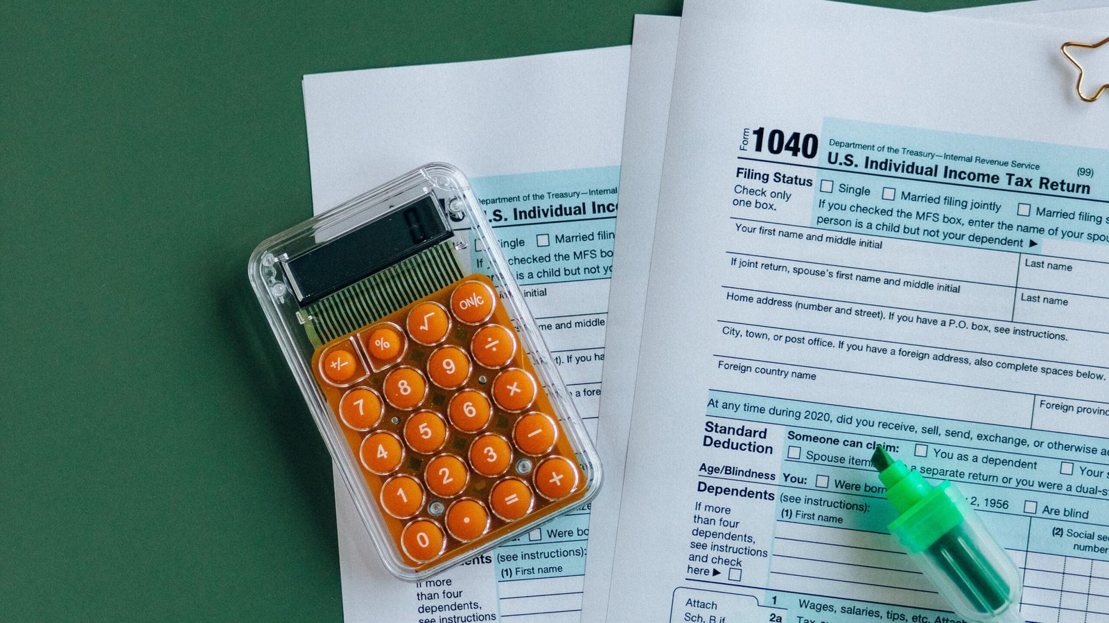 U.S. tax paperwork, calculator and stationery arranged on a desk for annual tax planning.