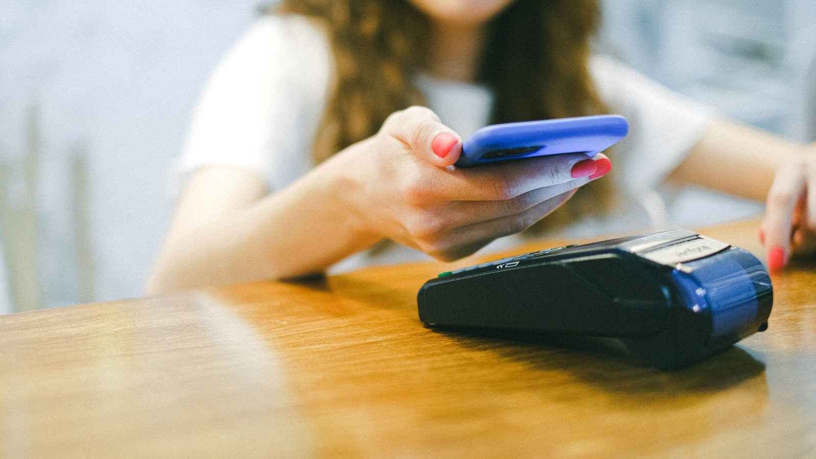 Person making a contactless mobile payment at a point-of-sale terminal.