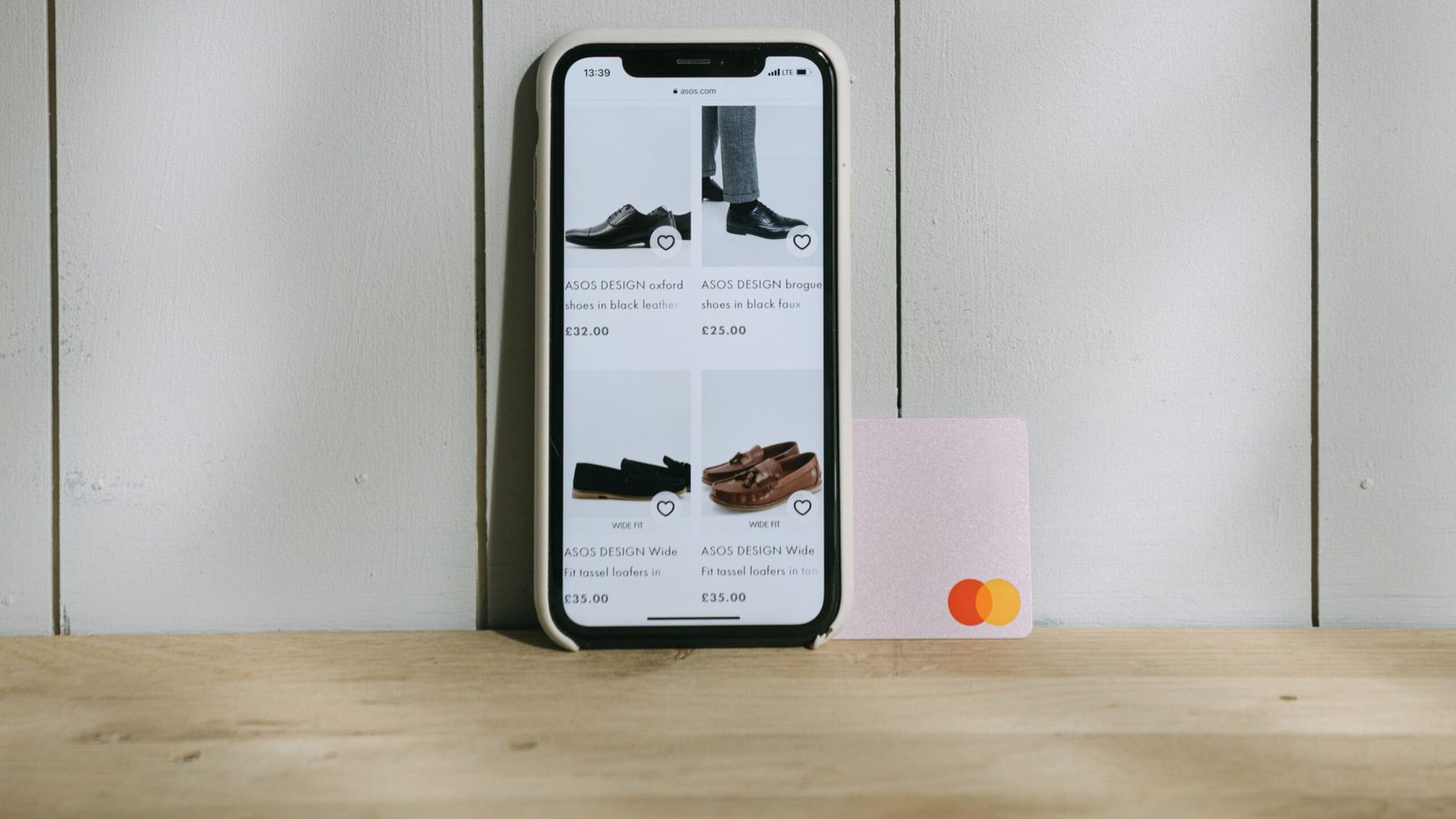 Smartphone displaying an online shop beside a payment card.
