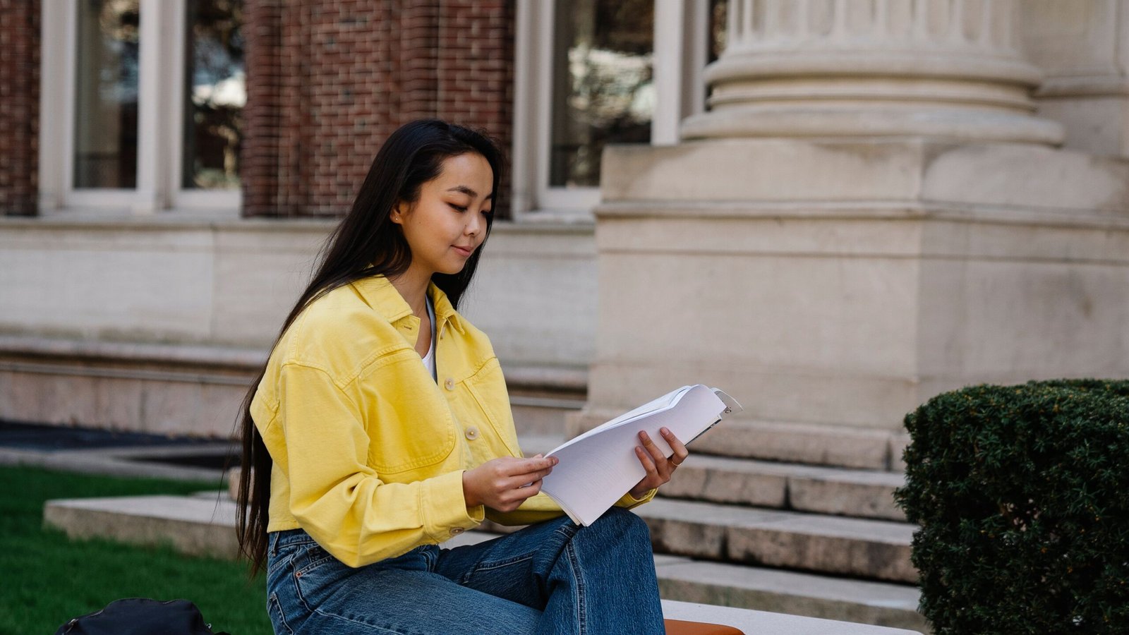 Student reviewing college notes on campus while comparing financial aid awards