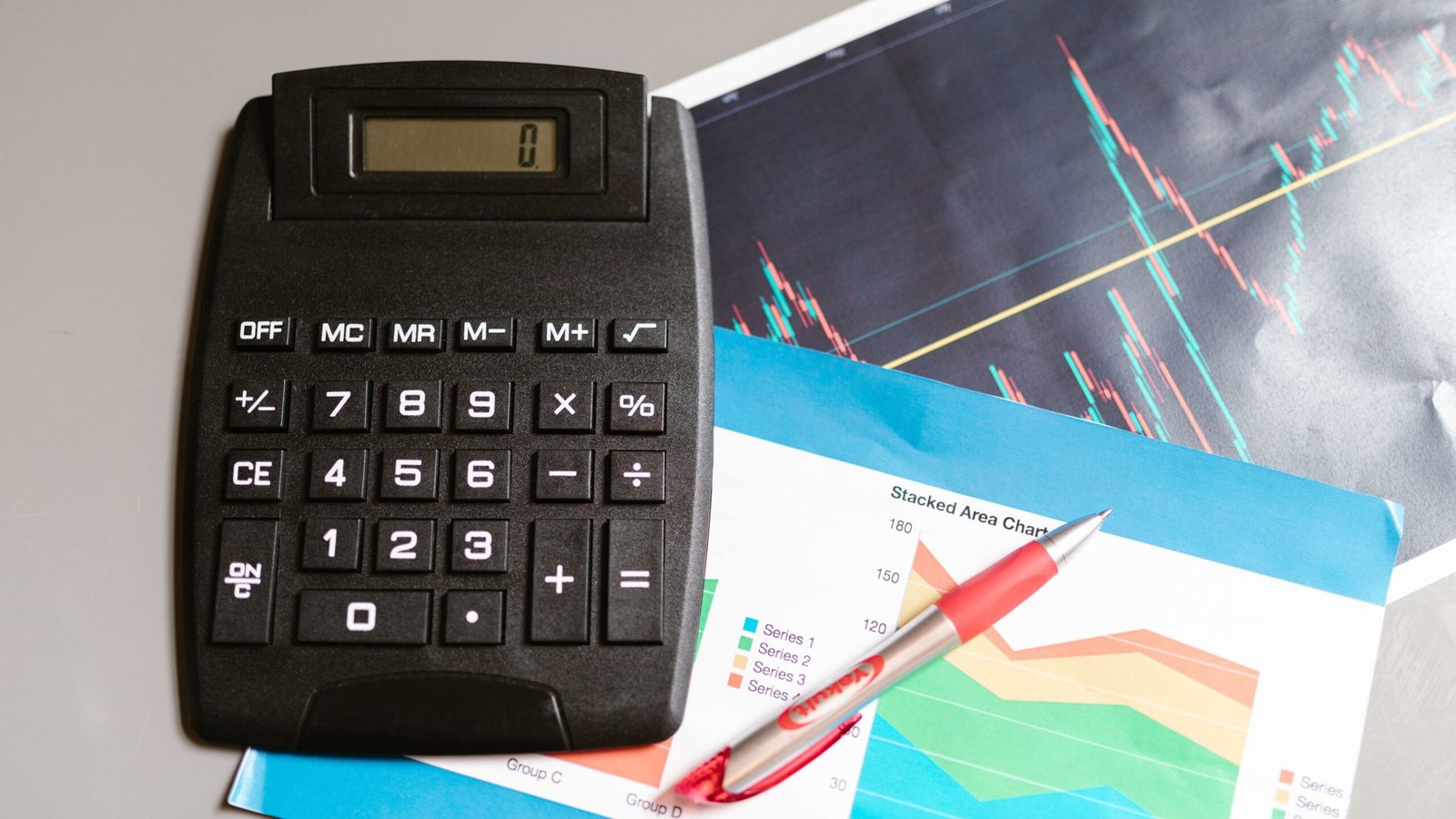 Calculator on a table beside financial charts for comparing small-loan costs and APR.