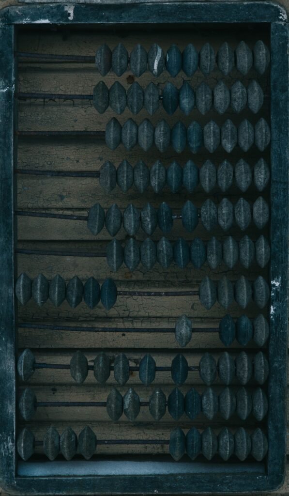 Rows of dark wooden beads in an old counting frame.