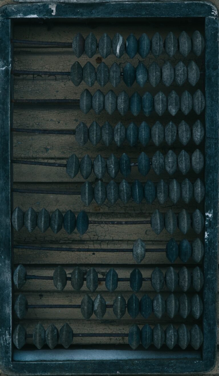 Rows of dark wooden beads in an old counting frame.