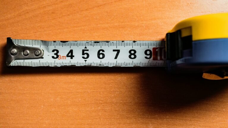 A metal tape measure extends across a wooden surface.