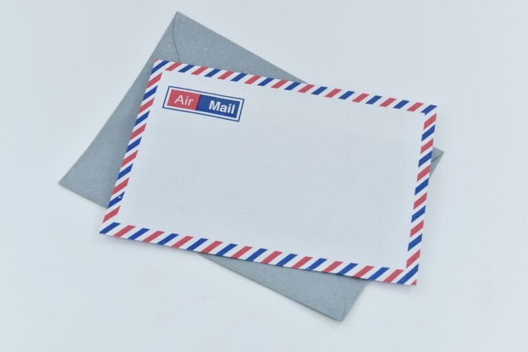 An airmail envelope with a blank address area and red-and-blue border resting over a gray envelope.