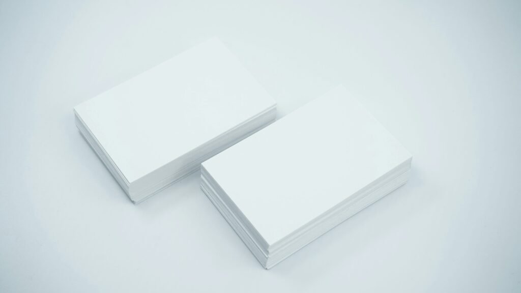 Two stacks of blank paper cards on a gray surface.