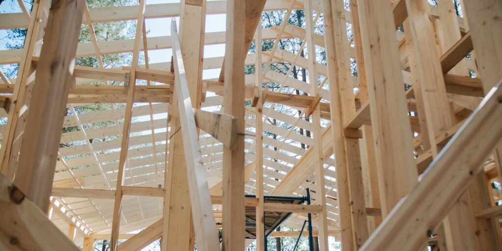 Exposed timber wall studs and roof framing inside a house under construction.