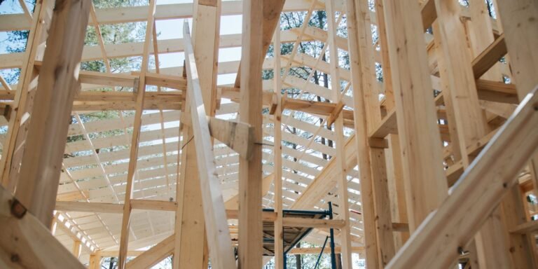 Exposed timber wall studs and roof framing inside a house under construction.