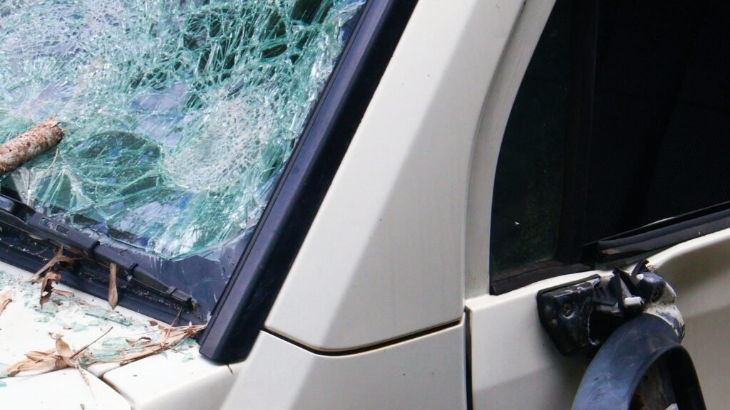 Shattered windshield and damaged side mirror on a car.