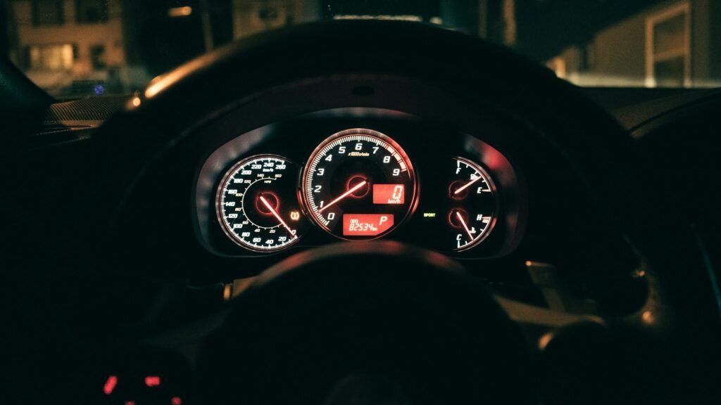 Illuminated vehicle gauges and an odometer showing kilometres.