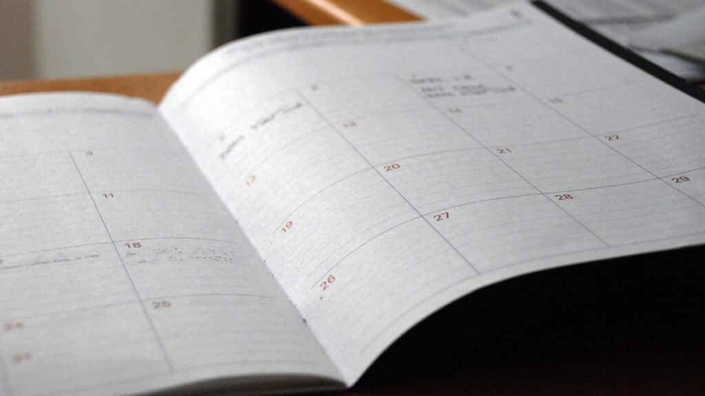 An open monthly planner on a wooden desk.