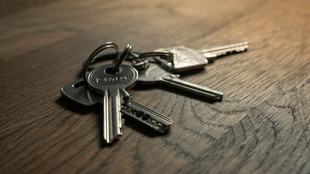 Metal keys on a ring resting on a wooden table.