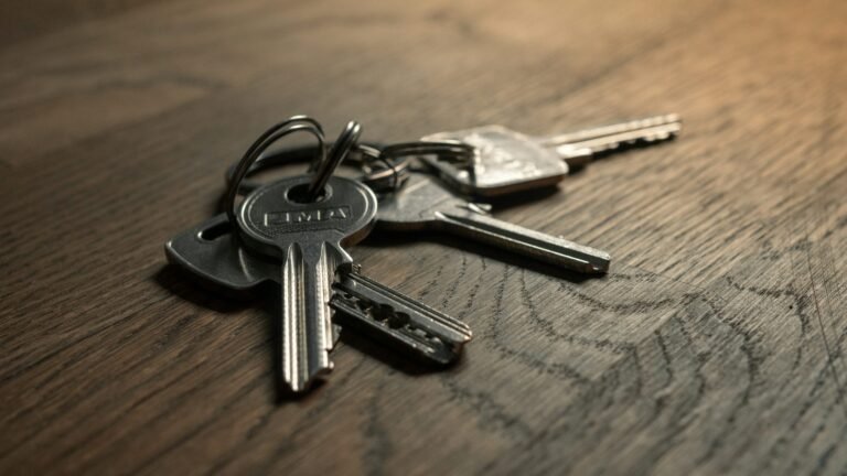 Metal keys on a ring resting on a wooden table.