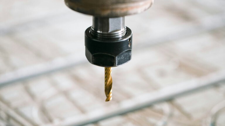 A milling-machine spindle and cutter positioned above a wooden work surface.