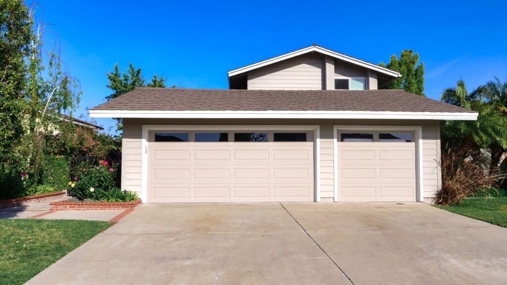A suburban house with a three-car garage, driveway and front lawn.