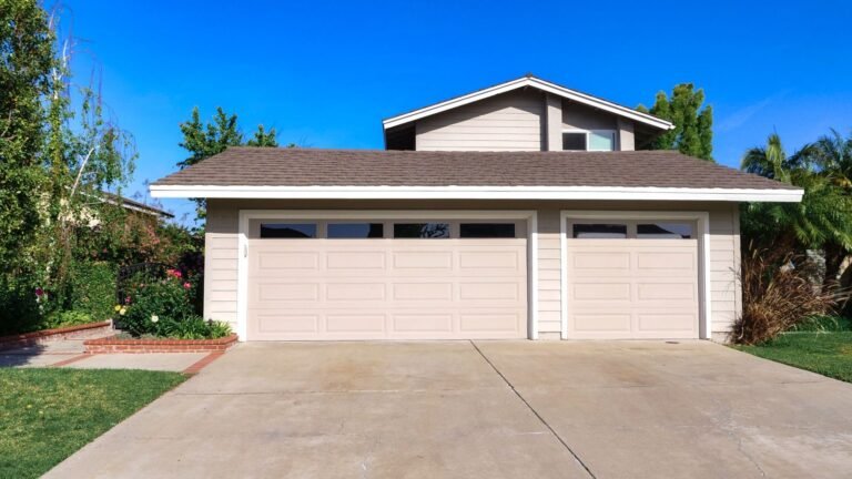 A suburban house with a three-car garage, driveway and front lawn.