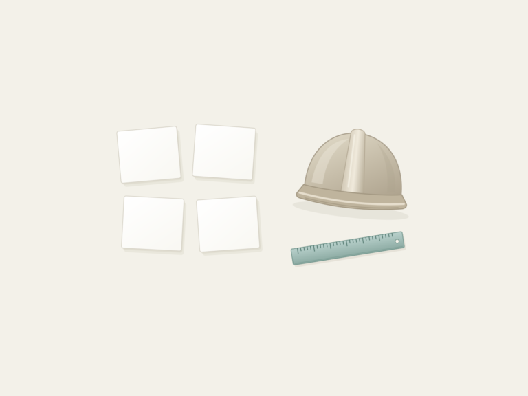 Four blank paper cards beside a ruler and hard hat.