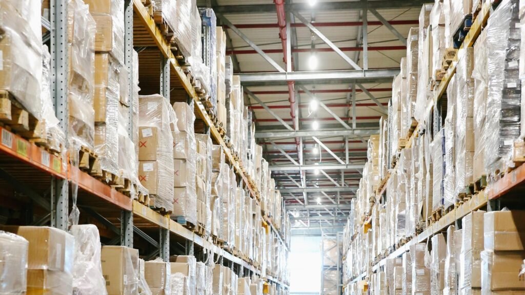 Wrapped cartons on tall shelves along a warehouse aisle.
