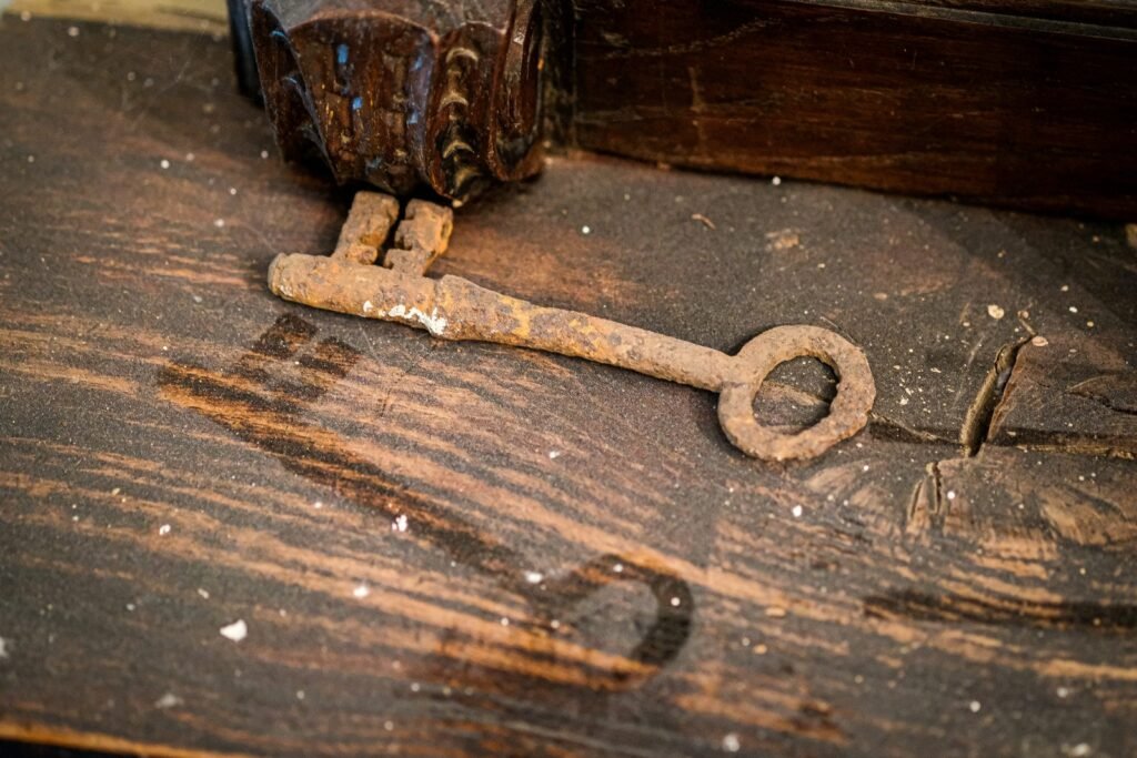 A rusty metal key rests on a worn wooden surface.