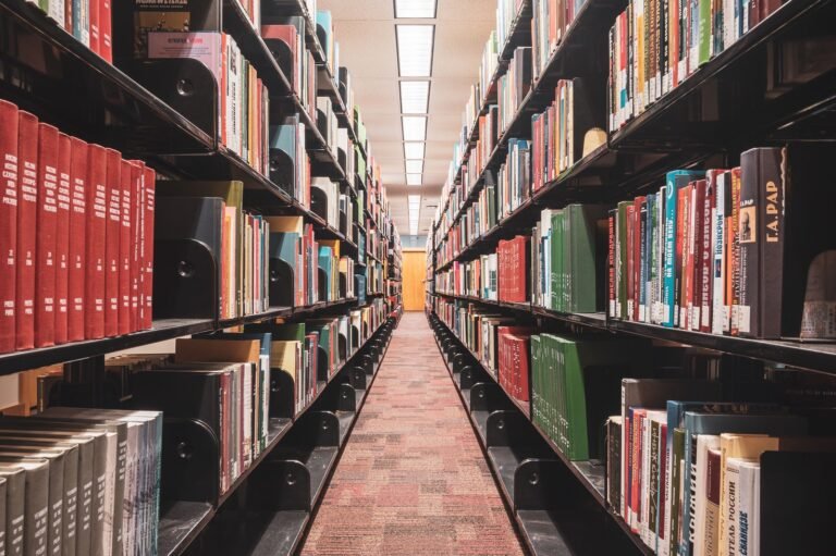An empty aisle between tall library bookshelves.