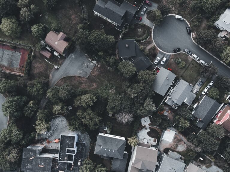 An overhead view of houses, trees, driveways and parked cars around a cul-de-sac.
