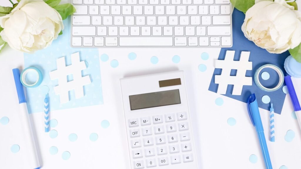 White calculator and keyboard with blue stationery and white flowers.