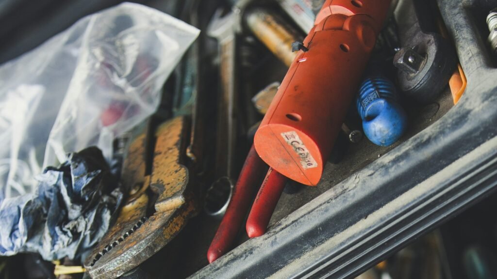Hand tools and an orange work light in an open tool chest.
