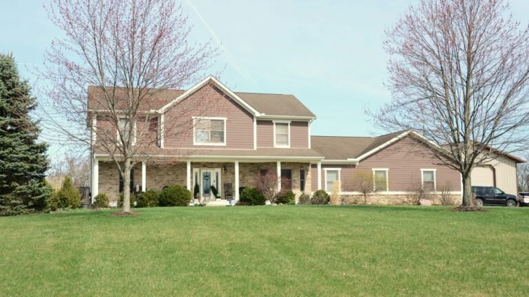 A two-story suburban house with a front porch and green lawn.