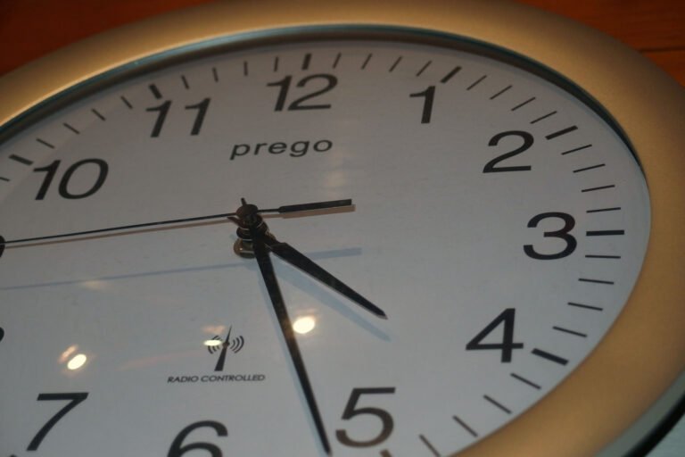 An angled close-up of a wall clock with black hands and numerals.